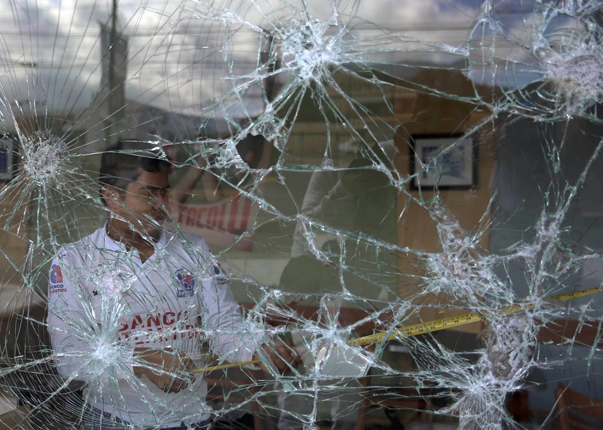 Empleados de un negocio limpian el local que fue saqueado por manifestantes en Tegucigalpa, Honduras