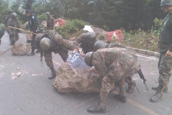 Soldados retiran  rocas colocadas  en la entrada a  Tuninchum, Tacajumulco. (Foto Prensa Libre: Aroldo Marroquín)