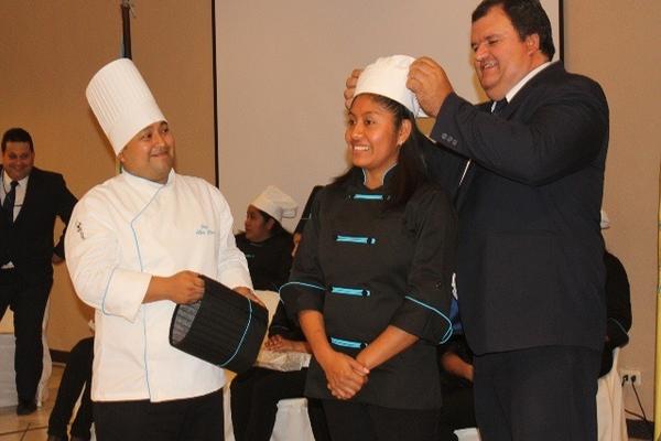 Luis Martínez, delegado del Intecap, coloca los distintivos de chefs a una de las participantes del curso, en Jutiapa. (Foto Prensa Libre: Óscar González) <br _mce_bogus="1"/>