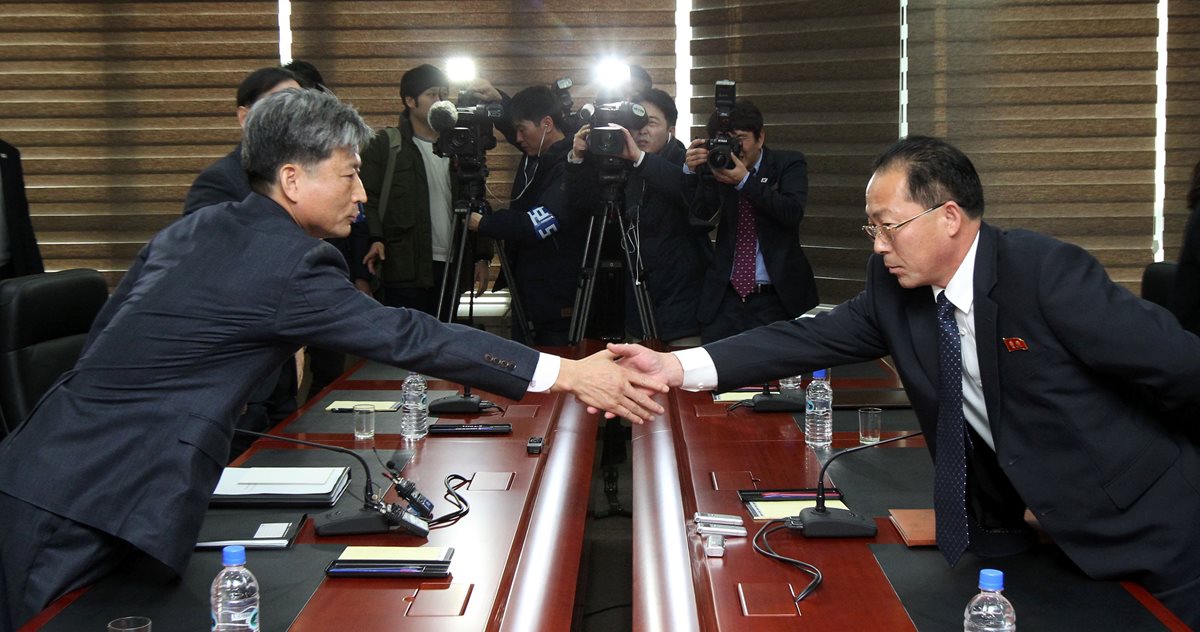 El viceministro de Unificación de Corea del Sur, Hwang Boo-Gi, (izquierda), y el delegado de Corea del Norte, Jon Jong-Su (derecha), se saludan al empezar la reunión. (Foto Prensa Libre: AFP).