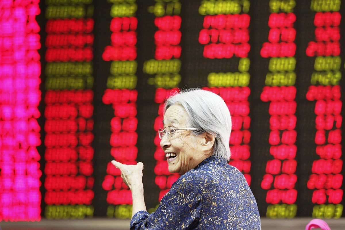 Una inversionista sonríe al ver los indicadores hoy en la bolsa de Pekín.  (PL-EFE)