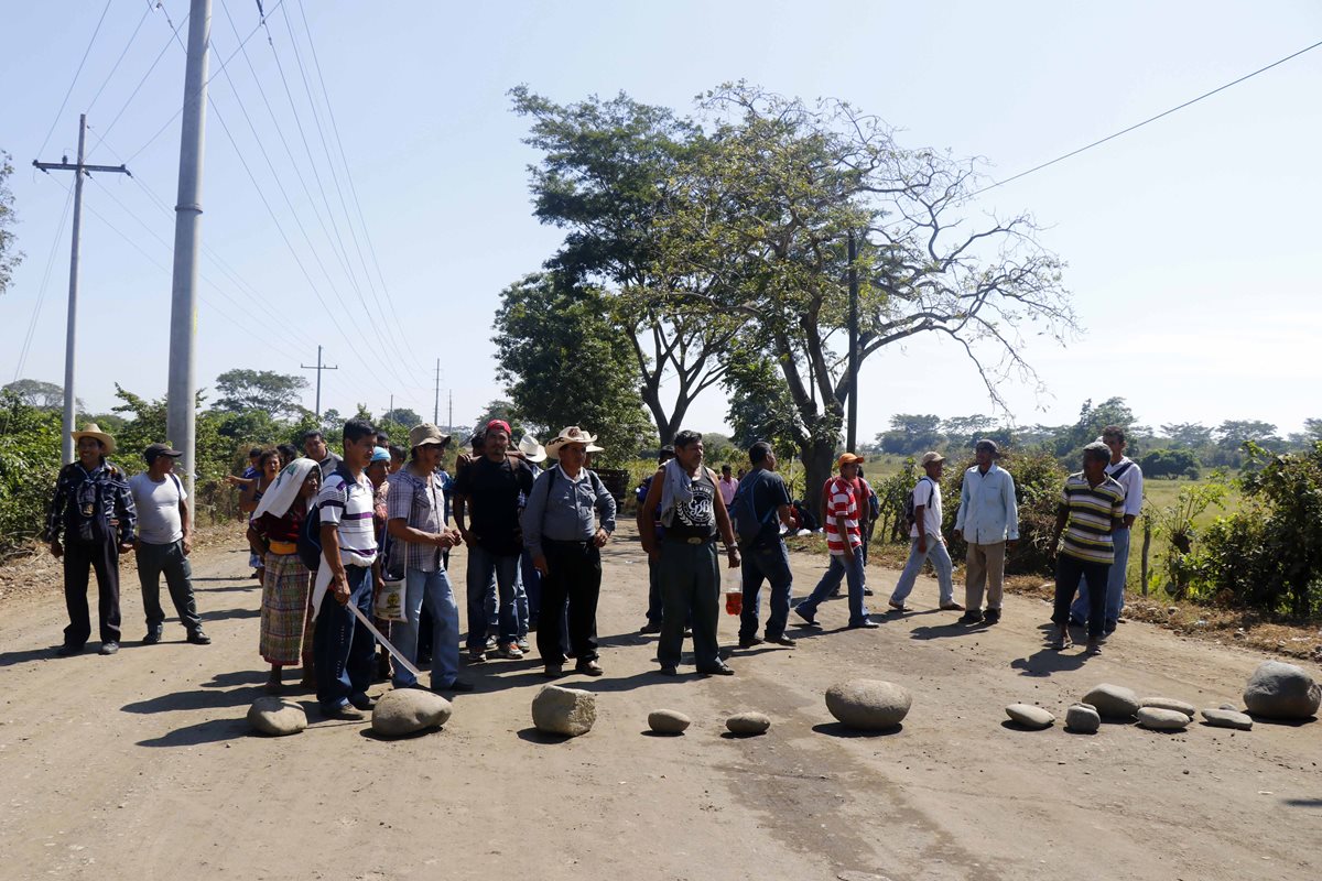 Pobladores de El Carmen bloquean el paso de camiones cañeros en la entrada de la comunidad. (Foto Prensa Libre: Rolando Miranda)