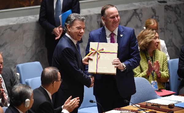 Juan Manuel Santos (R) presenta el acuerdo de paz a John Key,presidente del Consejo de Seguridad. (Foto Prensa Libre: AFP)