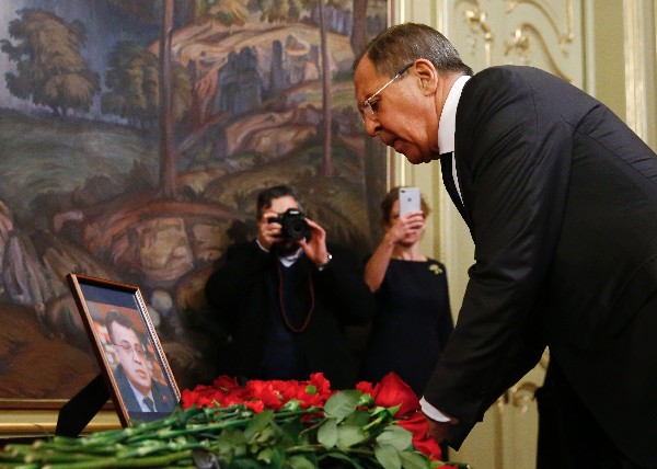 Serguéi Lavrov, pone flores frente a una foto de Andrei Karlov, embajador ruso en Turquía, que murió en Ankara. (Foto Prensa Libre: AFP)