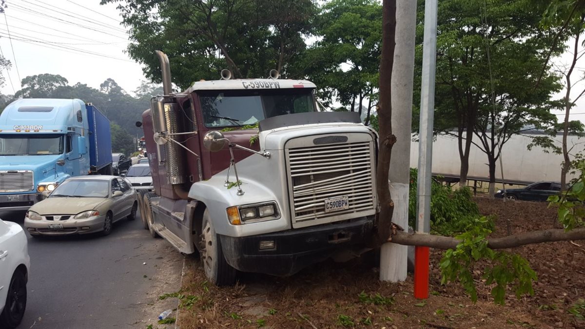 En el cruce a Bárcenas, Villa Nueva, -km 21- , un tráiler chocó contra un árbol y el piloto huyó. (Foto Prensa Libre: Cortesía PMT Villa Nueva)