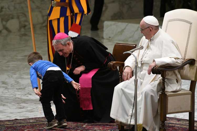 El papa Francisco y el prefecto de la casa papal, Georg Ganswein interactúan con el niño.