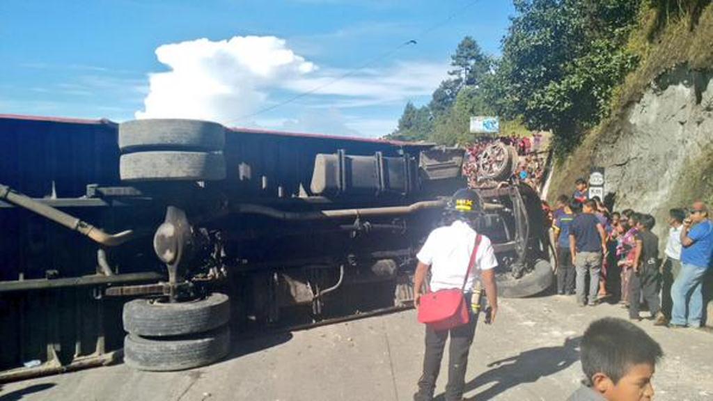 Curiosos observan el autobús accidentado en el km 115 de la ruta Interamericana, en Sololá. (Foto Prensa Libre: Bomberos Voluntarios)