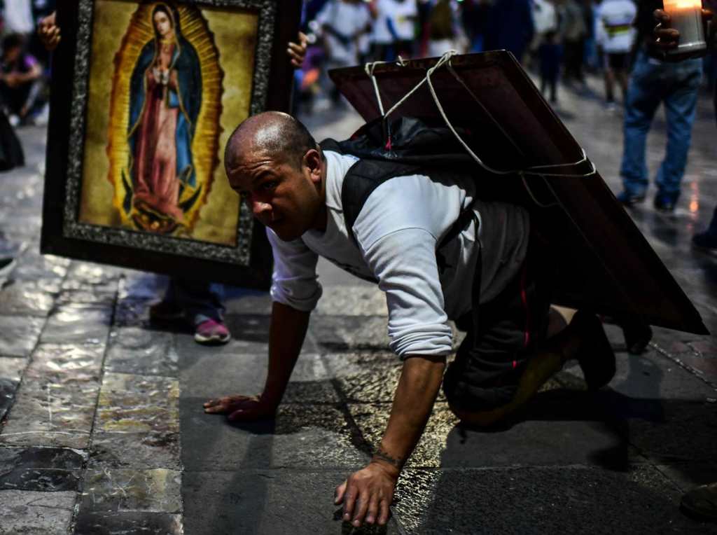 Un peregrino arrodillado se dirige a la entrada de la Basílica como una forma de sacrificio y ofrenda en veneración a la Virgen de Guadalupe