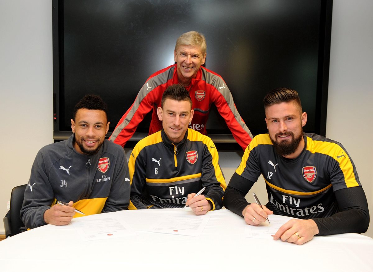 El técnico Arsene Wenger junto a los tres franceses después de firmar su renovación con el Arsenal. (Foto Prensa Libre: Arsenal)