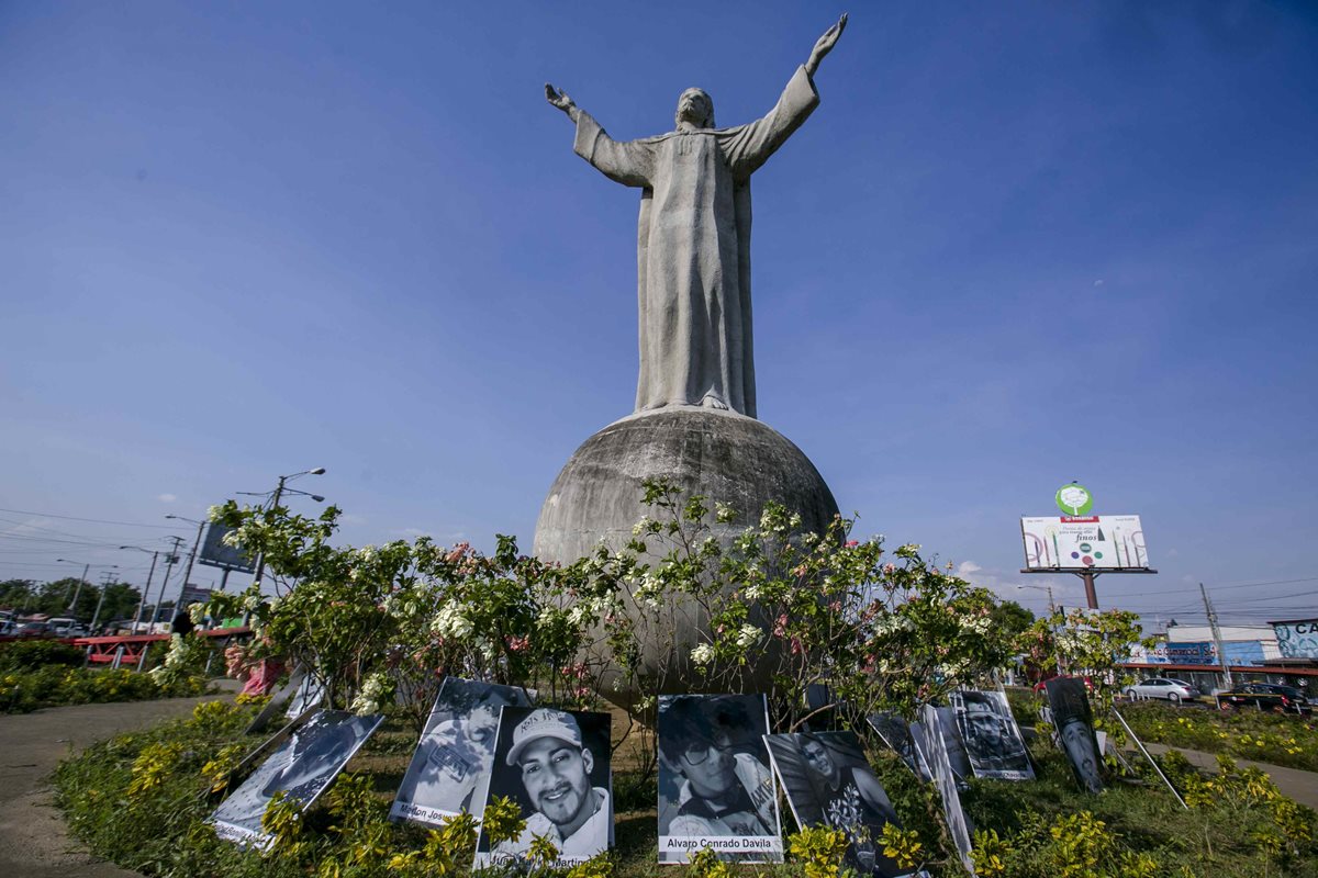 Fotografías de las personas muertas durante las protestas de la última semana son expuestas en la rotonda del Cristo en Managua.(Foto Prensa Libre:EFE).