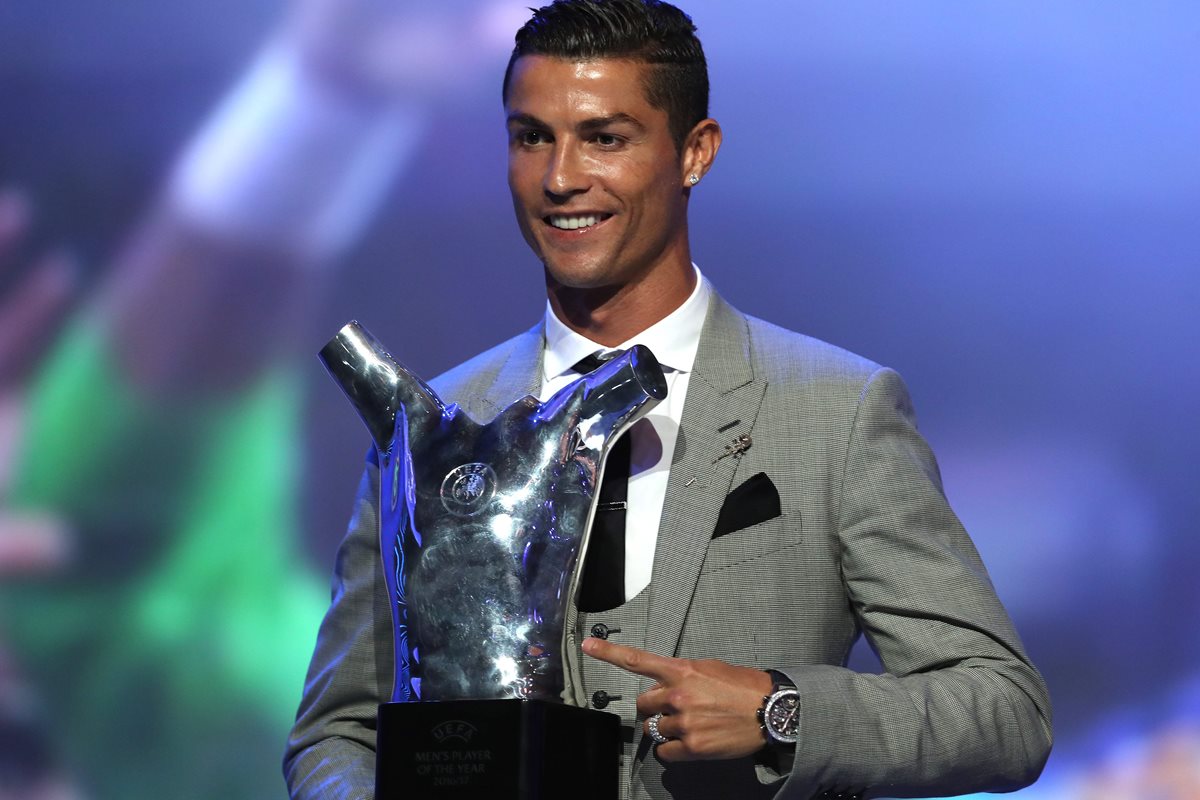 Cristiano Ronaldo muestra con alegría su tercer premio al mejor jugador de la UEFA. (Foto Prensa Libre: AFP)