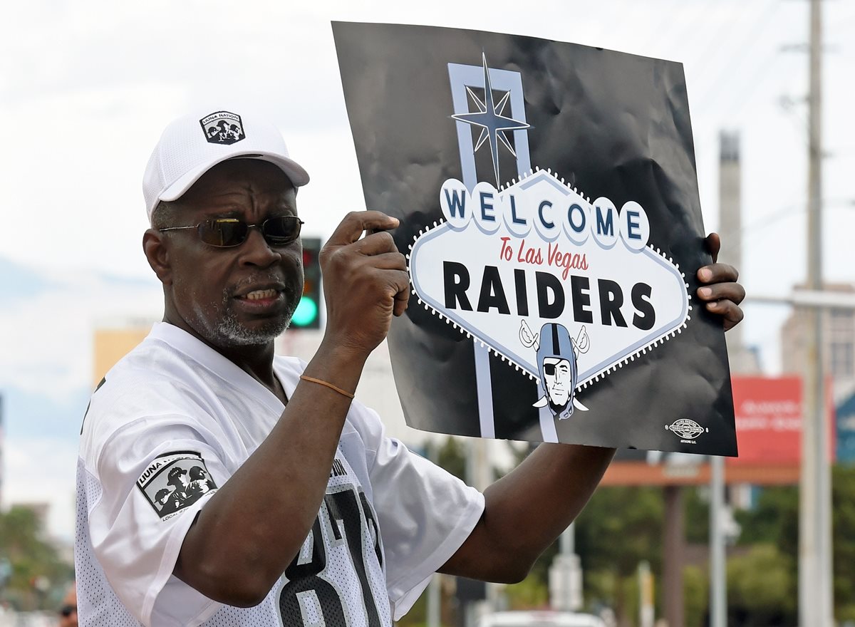 Un aficionado de los Raiders con un cartel, le da la bienvenida al equipo que se trasladaría a Las Vegas. (Foto Prensa Libre: AFP)