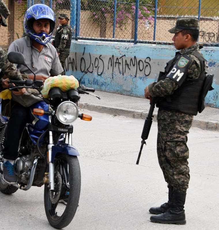 Efectivos la policía piden la identificación a un hondureño en el barrio el Bosque. (Foto Prensa Libre:AFP).
