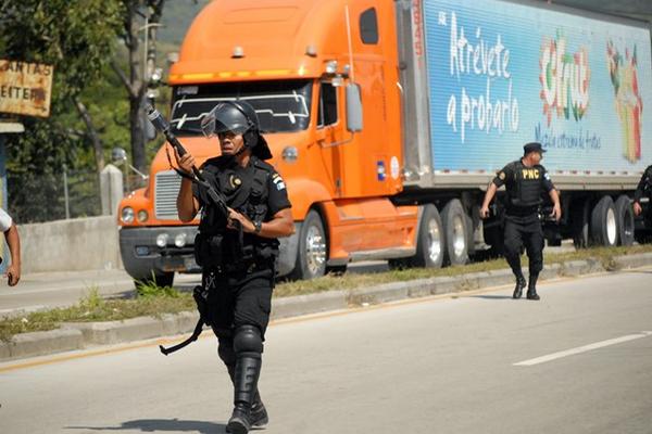 Agentes de la PNC durante el operativo para despejar la carretera. (Foto Prensa Libre: Hugo Oliva)