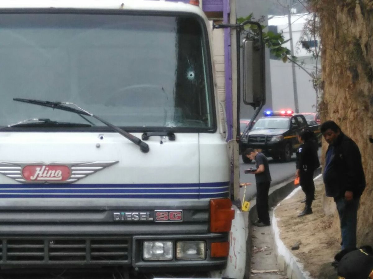 Peritos del MP recogen envidencia alrededor del camión, en la zona 18. (Foto Prensa Libre: Estuardo Paredes)