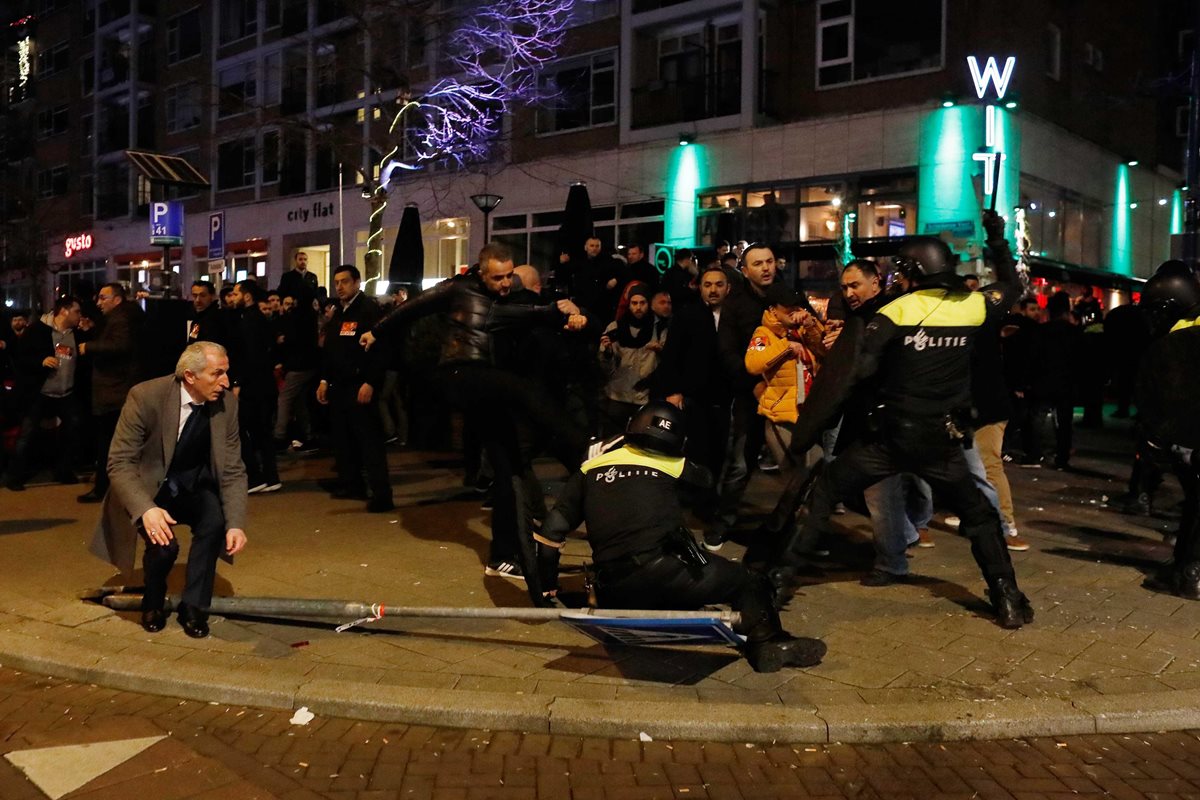 Manifestantes se enfrentan a la policía holandesa frente a la embajada de Turquía en Róterdam. (Foto Prensa Libre: EFE)