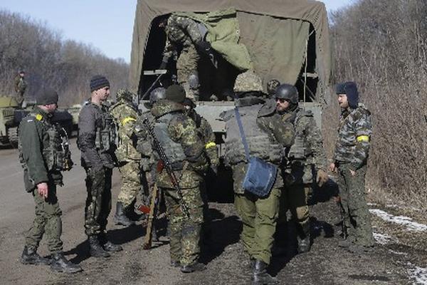 Soldados ucranianos suben a los vehículos en los que abandonaros una localidad.  (Foto Prensa Libre: EFE)
