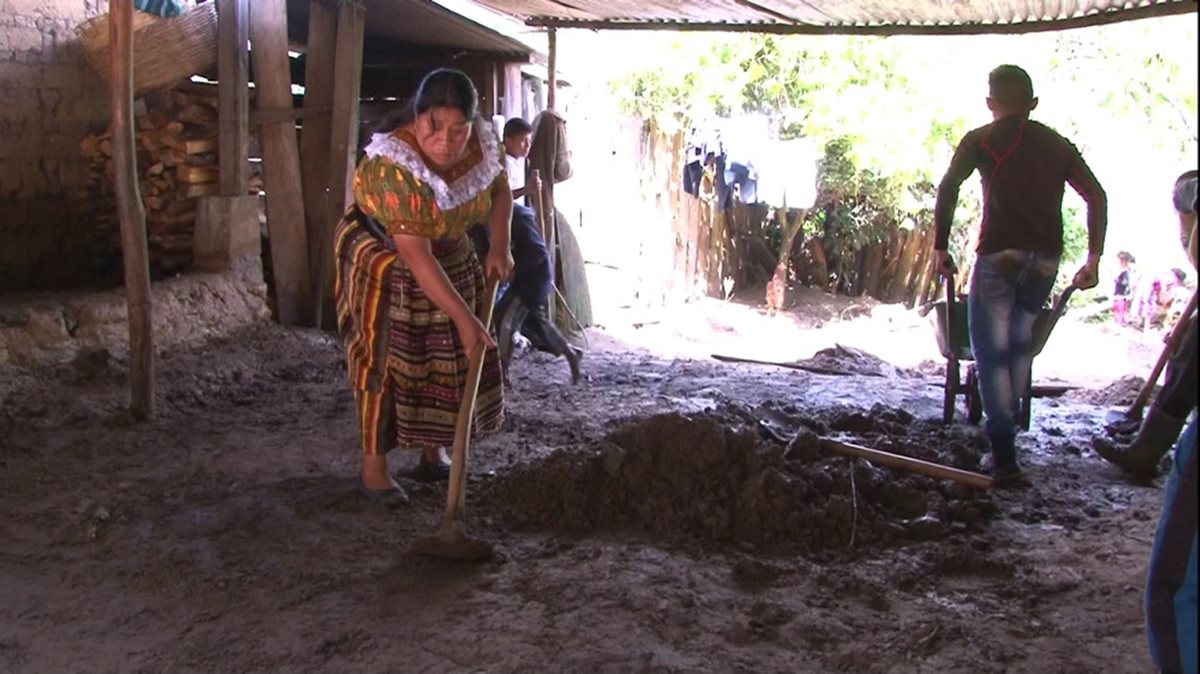 Una madre de familia saca el lodo de su vivienda, la cual fue inundada por el río Negro. (Foto Prensa Libre: Héctor Cordero)
