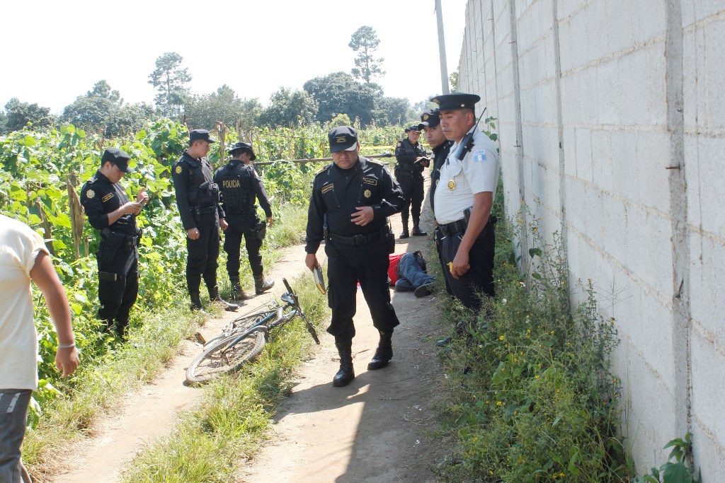 Agentes de la PNC y vecinos observan cadáver de agricultor, en la cabecera de ChimaltenangO. (Foto Prensa Libre: Víctor Chamalé)
