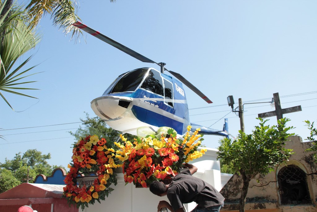 La madre de Mario Arreaza cumple el último deseo de su hijo al colocar sobre su tumba la réplica de un helicóptero. (Foto Prensa Libre: Víctor Gómez)