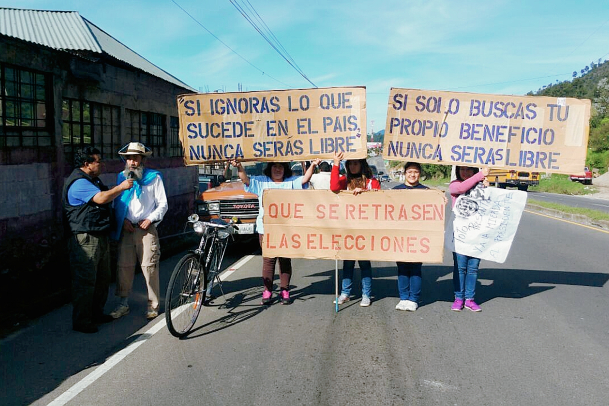 Oswaldo Ochoa es acompañado por algunos estudiantes en su paso por la ruta Interamericana, en Sololá, quienes portan pancartas. (Foto Prensa Libre: Édgar René Sáenz)