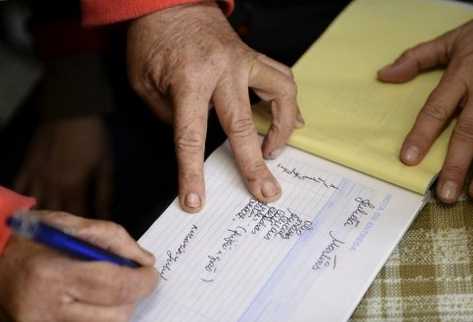 Una mujer firma un recibo tras recibir ayuda alimenticia en Olhao, en el sur de Portugal, el 14 de diciembre de 2012. (Foto Prensa Libre: AFP)
