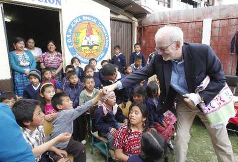 El director de Unicef, Anthony Lake, saluda a un niño, en su visita ayer a Huehuetenango.