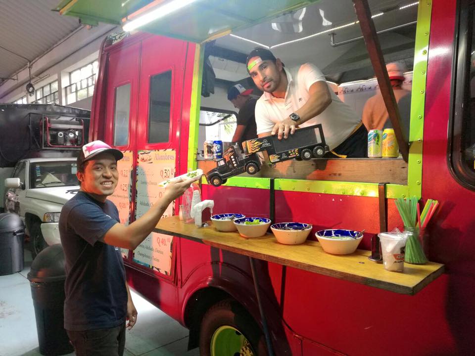 Dos personas intercambiando un juguete por una porción de tacos.(Foto Prensa Libre: Cortesía)