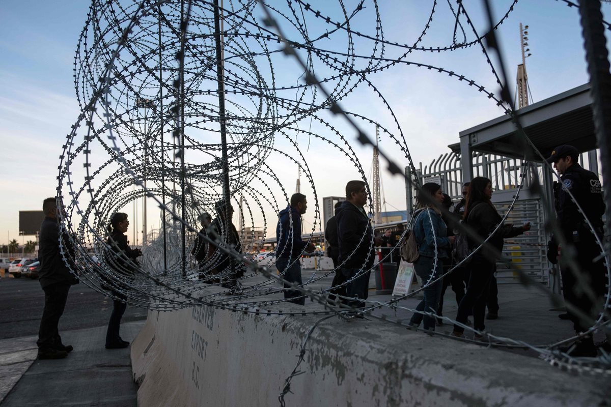 Un agente pide visas a viajeros en el punto fronterizo de San Ysidro. (Foto Prensa Libre: AFP)