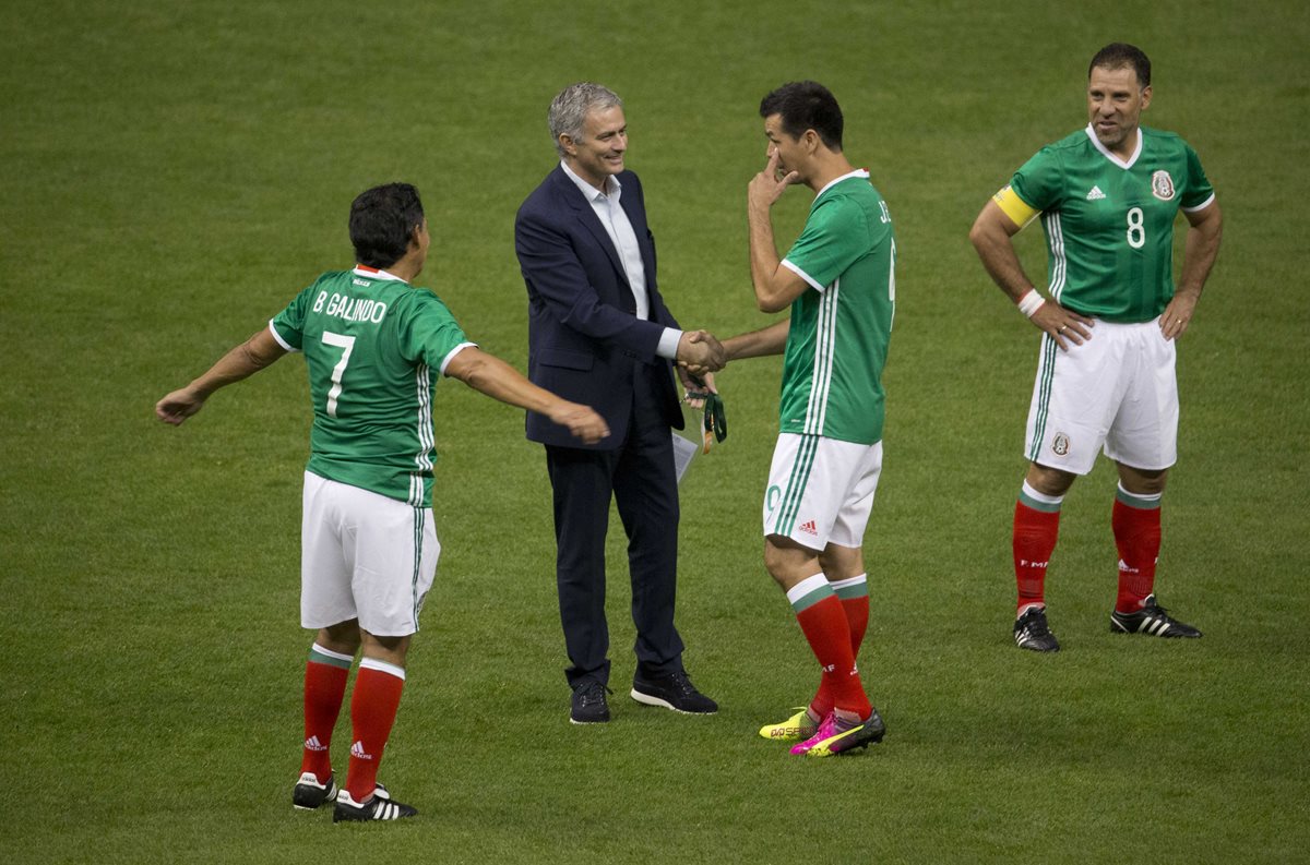 El portugués José Mourinho saluda al ex delantero azteca Jared Borgetti, ante la mirada de Alberto García Aspe y Benjamín Galindo. (Foto Prensa Libre: AP)