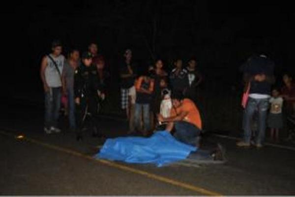 Curiosos observan el cadáver de José Ovando Chan, quien murió atropellado en San Benito. (Foto Prensa Libre: Rigoberto Escobar)