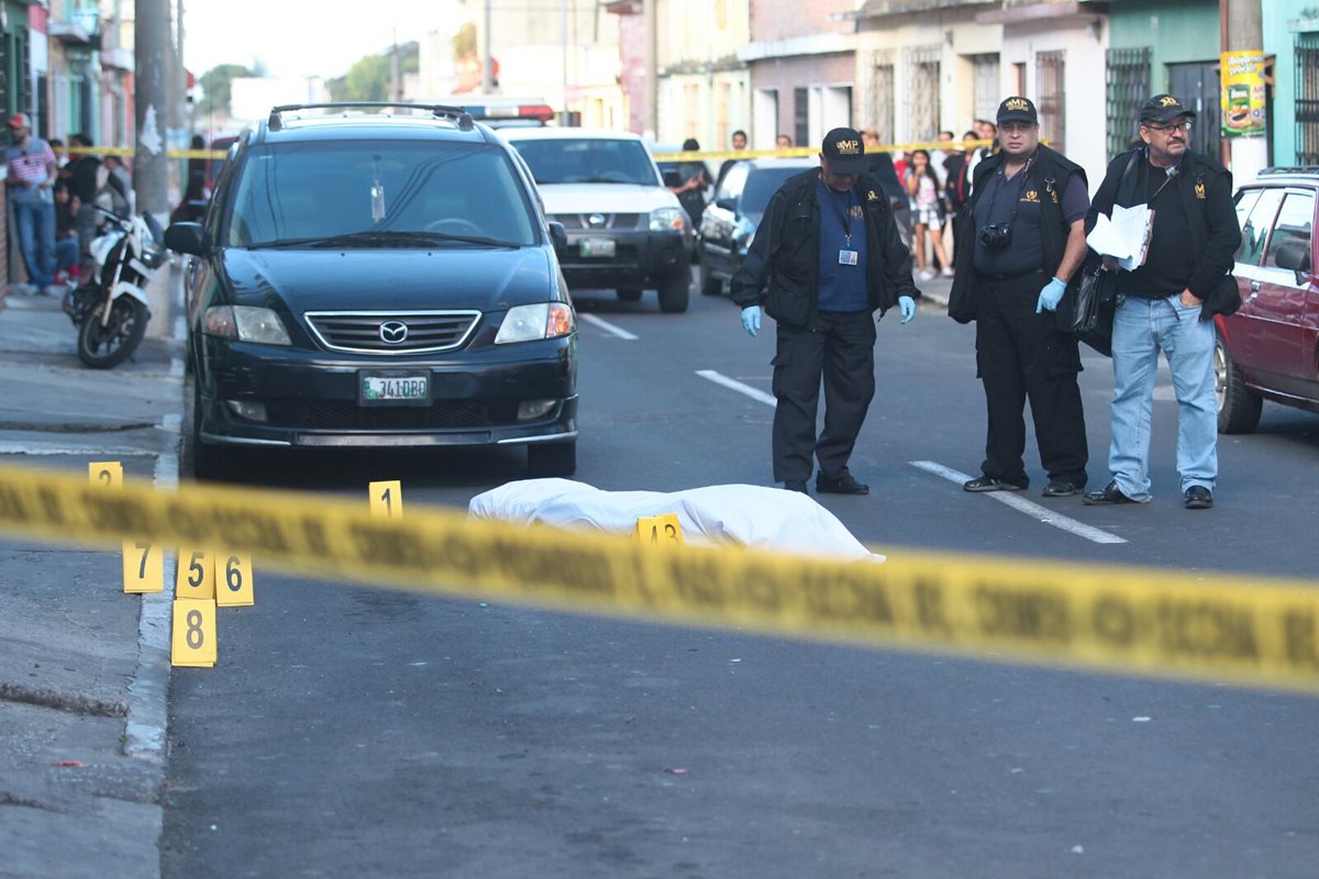 El cuerpo de Santizo quedó en la calle, mientras investigadores inspeccionan la escena. (Foto Prensa Libre: Álvaro Interiano)