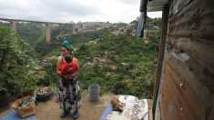 Romelia Gutiérrez carga a su hijo en el patio de su casa, en un barranco de la zona 7 capitalina. El peligro es evidente. (Foto Prensa Libre: Esbin García)