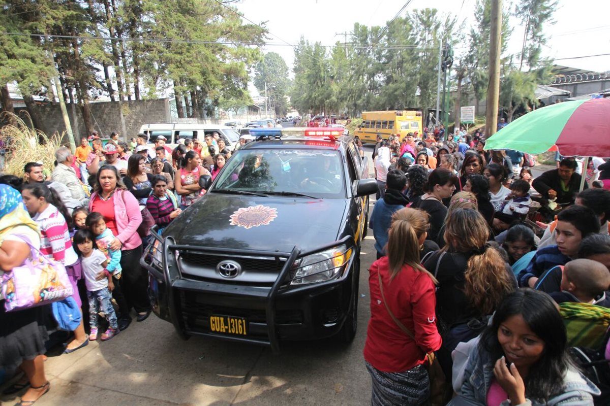 Un autopatrulla ingresa al penal en medio de los familiares que esperan poder visitar a los reos. (Foto Prensa Libre: Erick Avila)