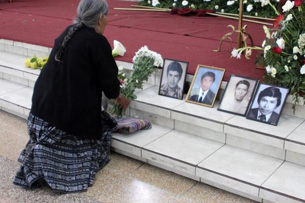 En la catedral de Cobán, una mujer coloca un ramo de flores junto a cuatro fotografías de personas desaparecidas en el conflicto armado.(Foto Prensa Libre: Eduardo Sam) <br _mce_bogus="1"/>