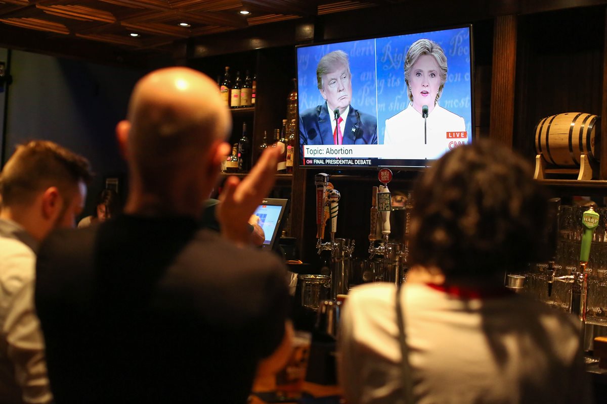 Personas obsevan el tercer debate presidencial en un restaurante de Carolina del Norte. (Foto Prensa Libre: AP).
