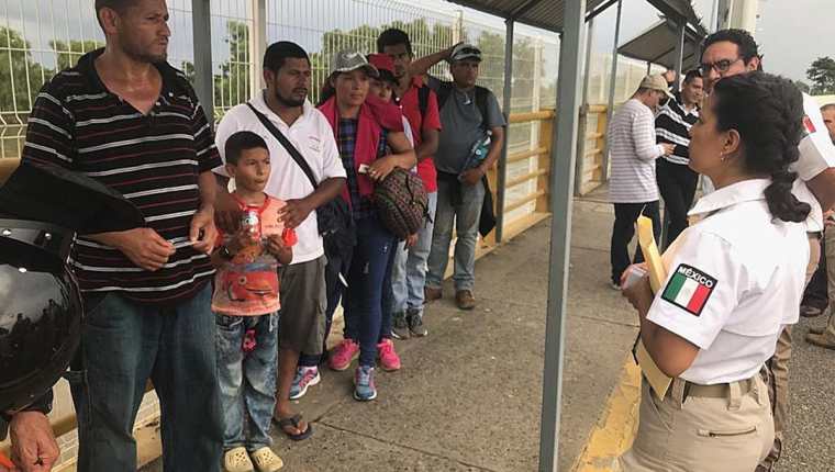 Personal del Instituto Nacional de Migración mexicano atiende a uno de los primeros grupos de nicaragüenses que llegaron a la frontera, después de un acuerdo para gestionar asilo. (Foto Prensa Libre: EFE)