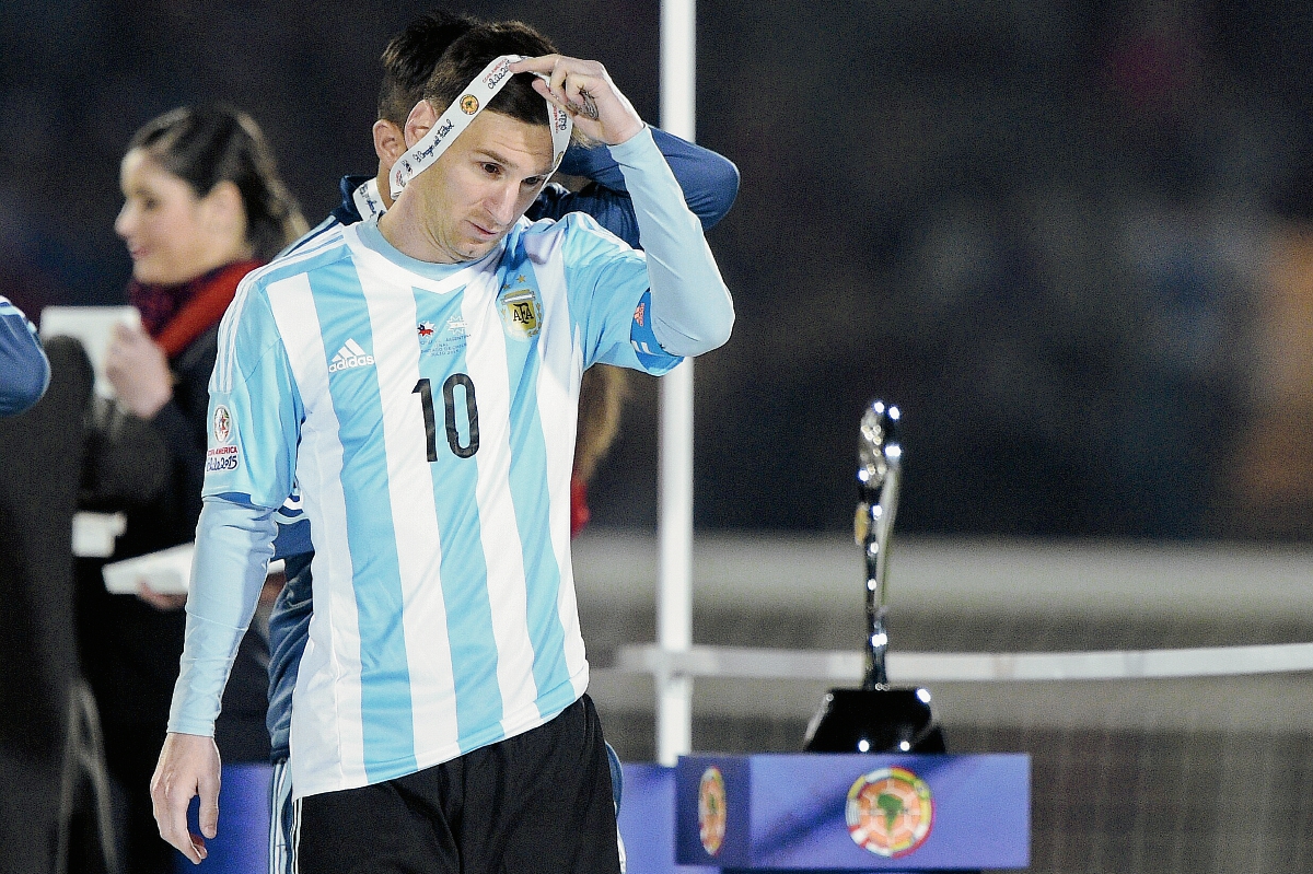 Lionel Messi se quita la medalla del segundo lugar, luego de perder la final de la Copa América contra Chile (Foto Prensa Libre: AFP)