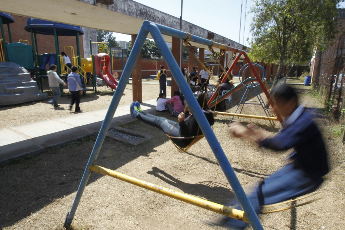 Niños juegan los columpios en el Hogar Rafael Ayau, zona 1. (Foto Prensa Libre: Paulo Raquec)