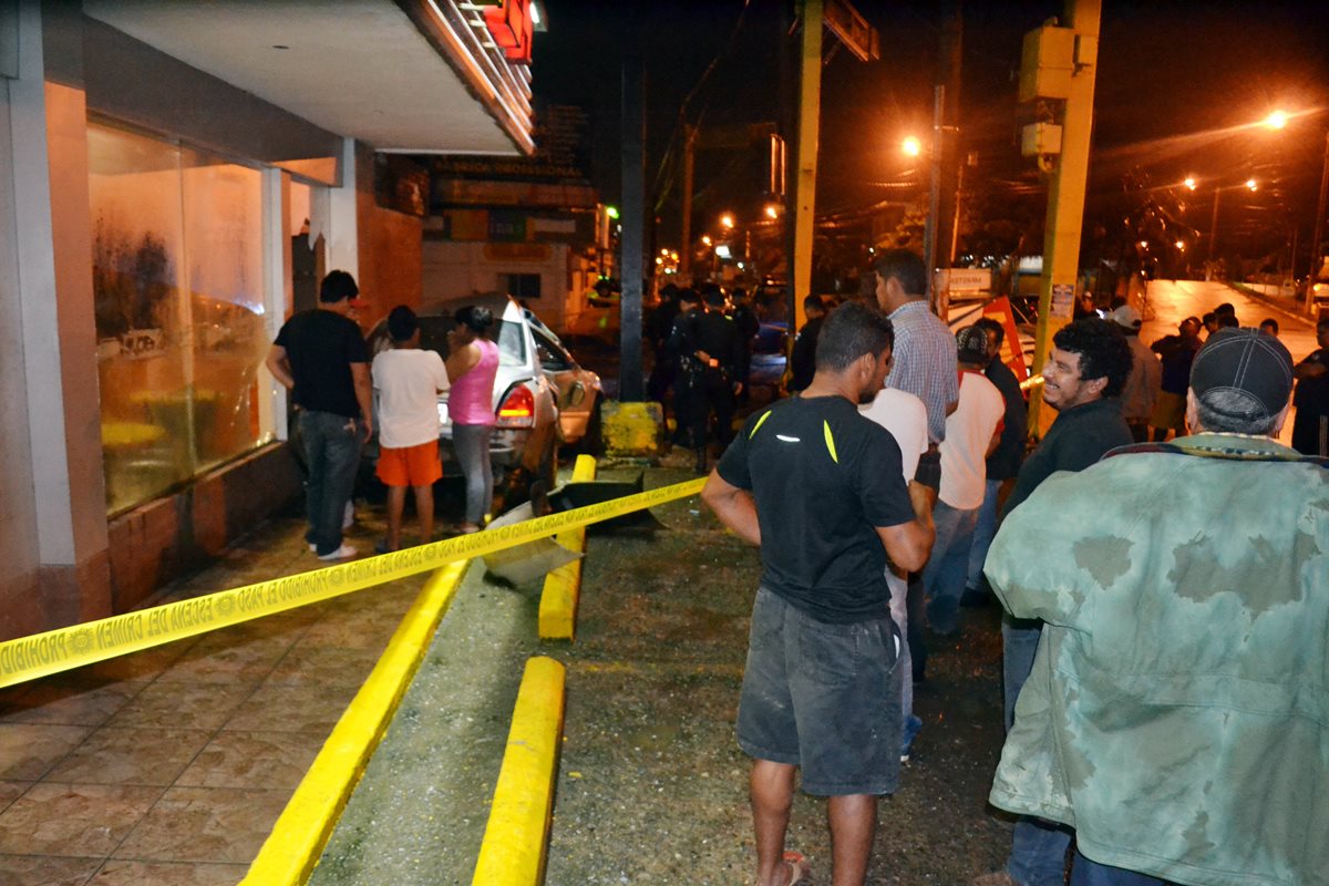 Agentes de la PNC resguardan el lugar donde un automovilista arrolló a dos personas, en Puerto Barrios, Izabal. (Foto Prensa Libre: Edwin Perdomo)