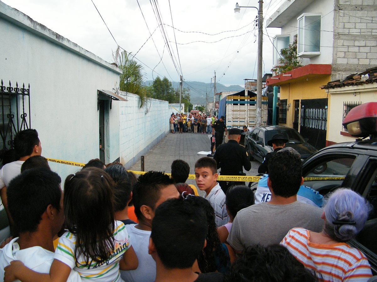Policías y curiosos en la escena del doble crimen, en Sanarate, El Progreso. (Foto Prensa Libre: Héctor Contreras)