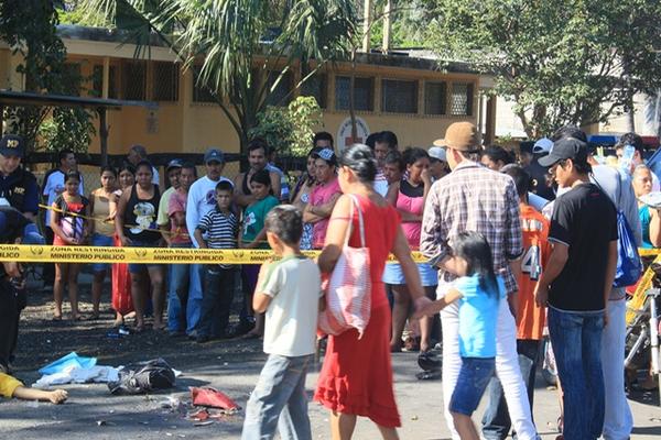 Curiosos observan el cuerpo del motociclista que se estrelló contra una retroexcavadora de la comuna de Escuintla. (Melvin Sandoval)<br _mce_bogus="1"/>