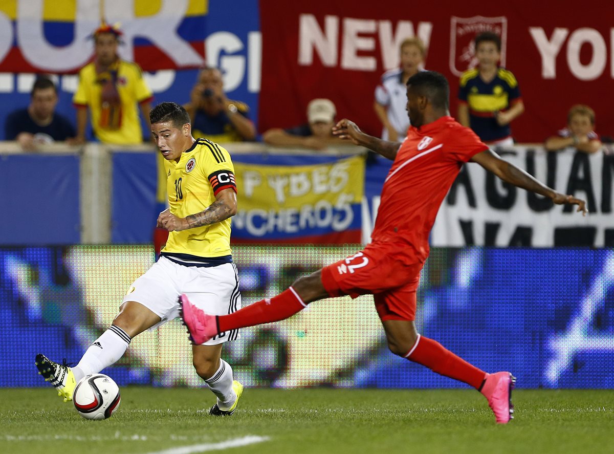 James Rodríguez trata de retener el balón ante la presión de Carlos Ascues de Perú en el partido amistoso de ayer. (Foto Prensa Libre: AP)
