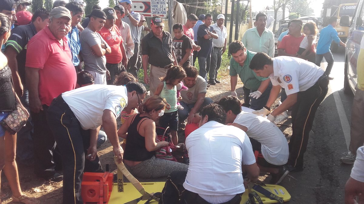 Socorristas atienden a las cinco personas que viajaban en una motocicleta y fueron arrollados.(Foto Prensa Libre: Jorge Tizol)