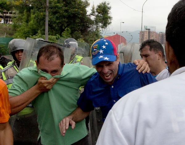Henrique Capriles (c) reacciona a los efectos del gas pimienta.(AFP).