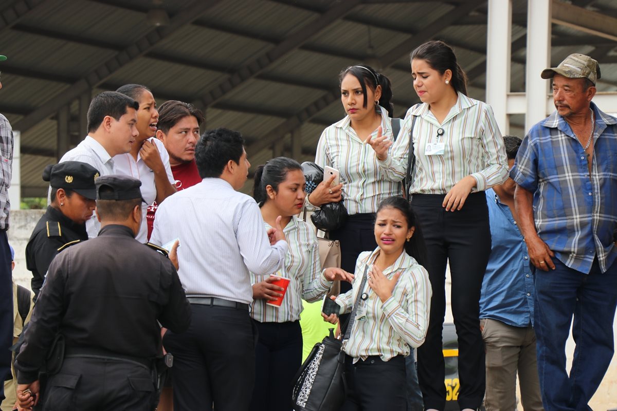 Compañeros de trabajo del joven asesinado, consternados en el lugar de los hechos. (Foto Prensa Libre: Mario Morales)