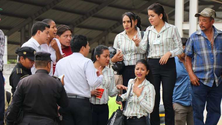 Compañeros de trabajo del joven asesinado, consternados en el lugar de los hechos. (Foto Prensa Libre: Mario Morales)