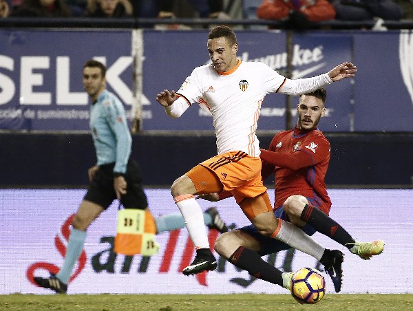 El delantero del Valencia, Rodrigo, intenta superar la entrada del defensa de Osasuna, Unai García. (Foto Prensa Libre: AFP).