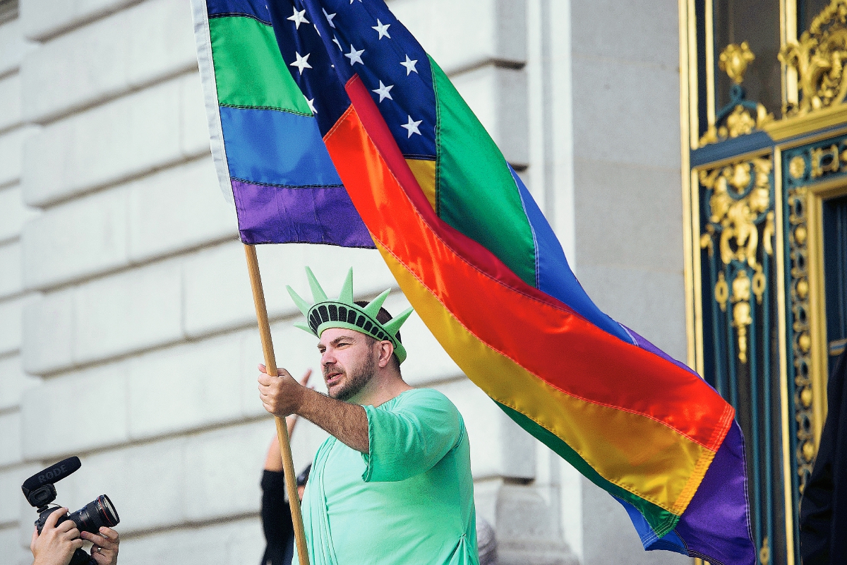 Un estadounidense porta una bandera del arco iris celebra la la decisión de la Corte Suprema de Estados Unidos. (Foto Prensa Libre:AP).