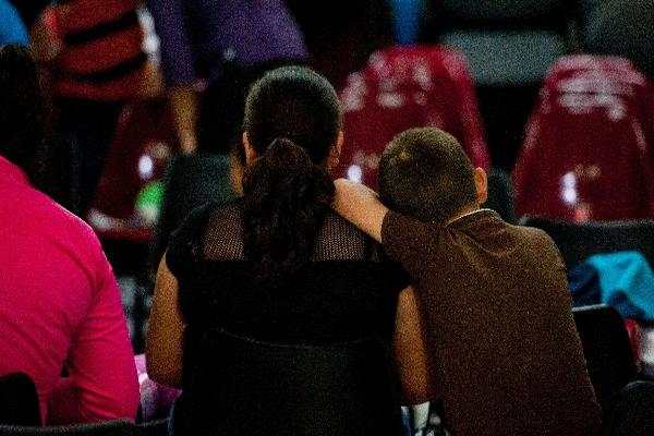 Una mujer y su hijo espera la llegada de niños migrantes en El Salvador. (Foto Prensa Libre: AFP)<br _mce_bogus="1"/>